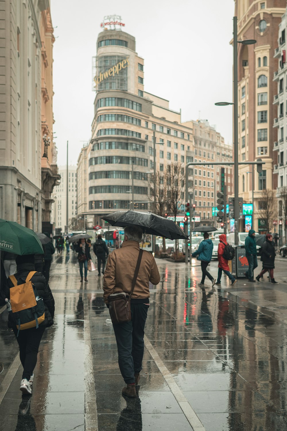 Un homme marchant dans une rue tenant un parapluie