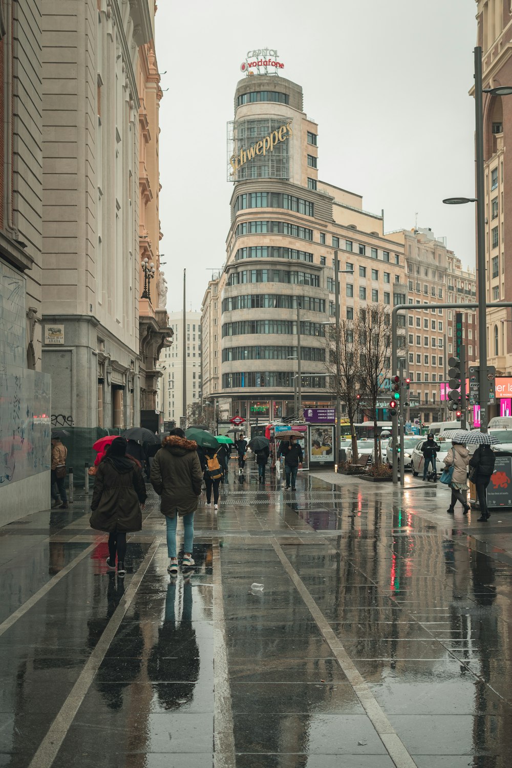 Un gruppo di persone che camminano lungo una strada tenendo ombrelli