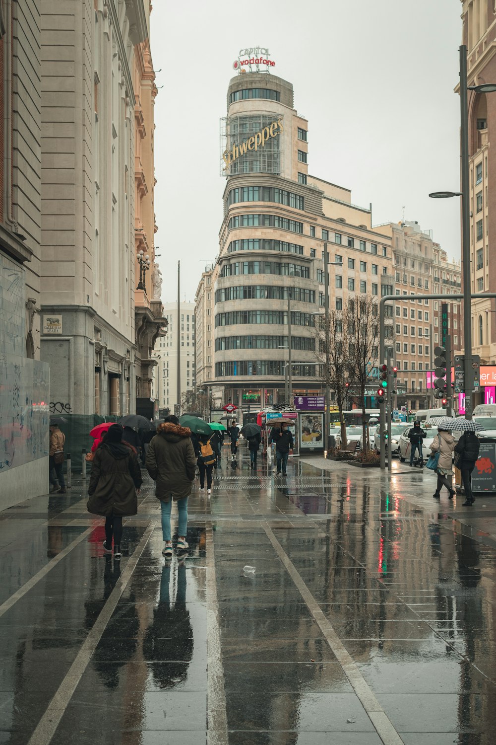 a group of people walking down a street holding umbrellas