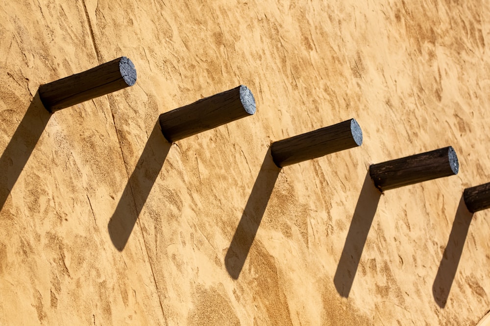 a row of wooden posts sitting on top of a wooden wall