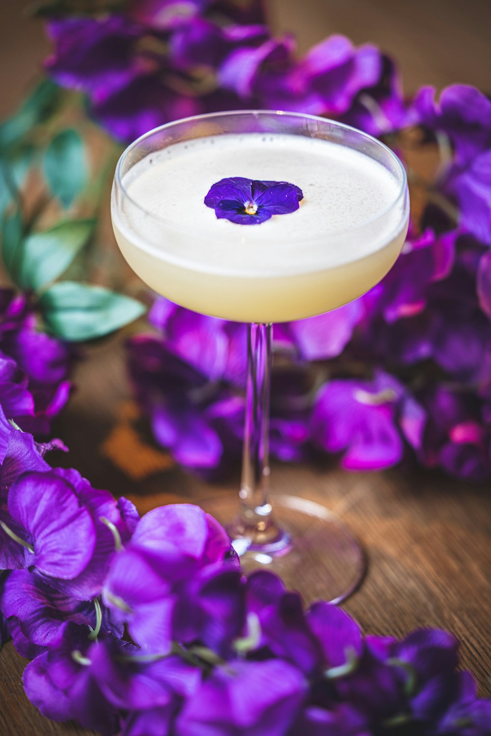 a martini with a purple flower on the rim
