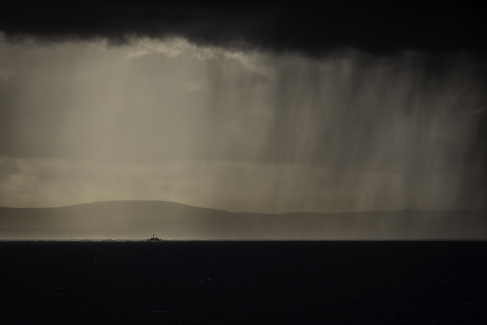 a black and white photo of a boat in the ocean