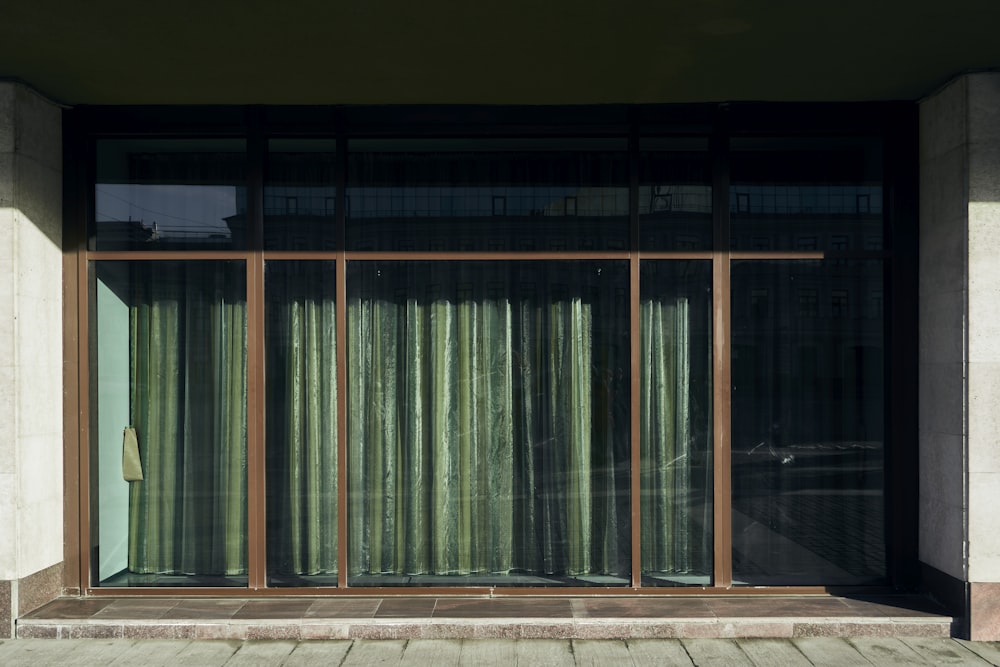 a window with a green curtain on the outside of it