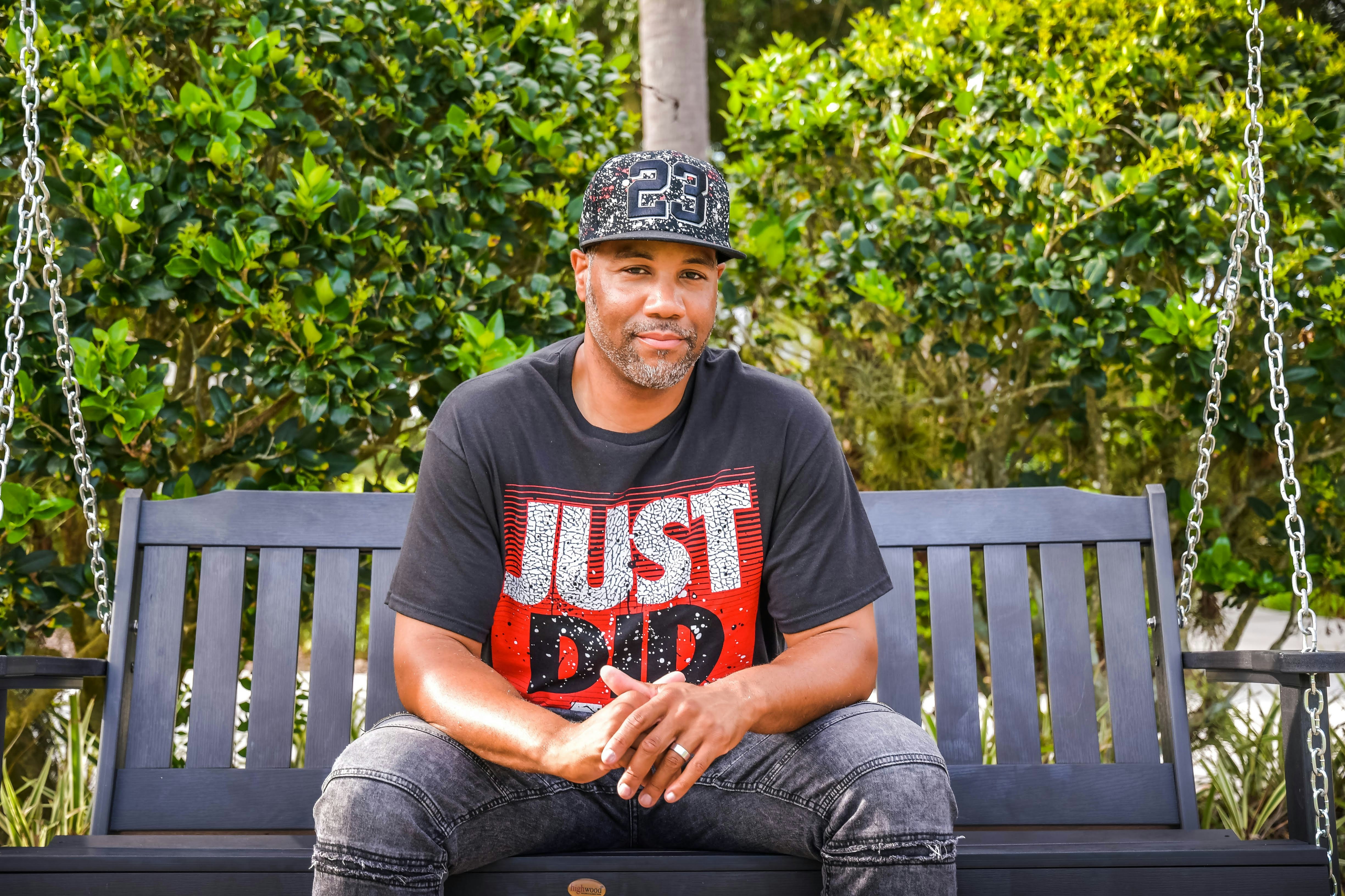 a man sitting on a swing in a park