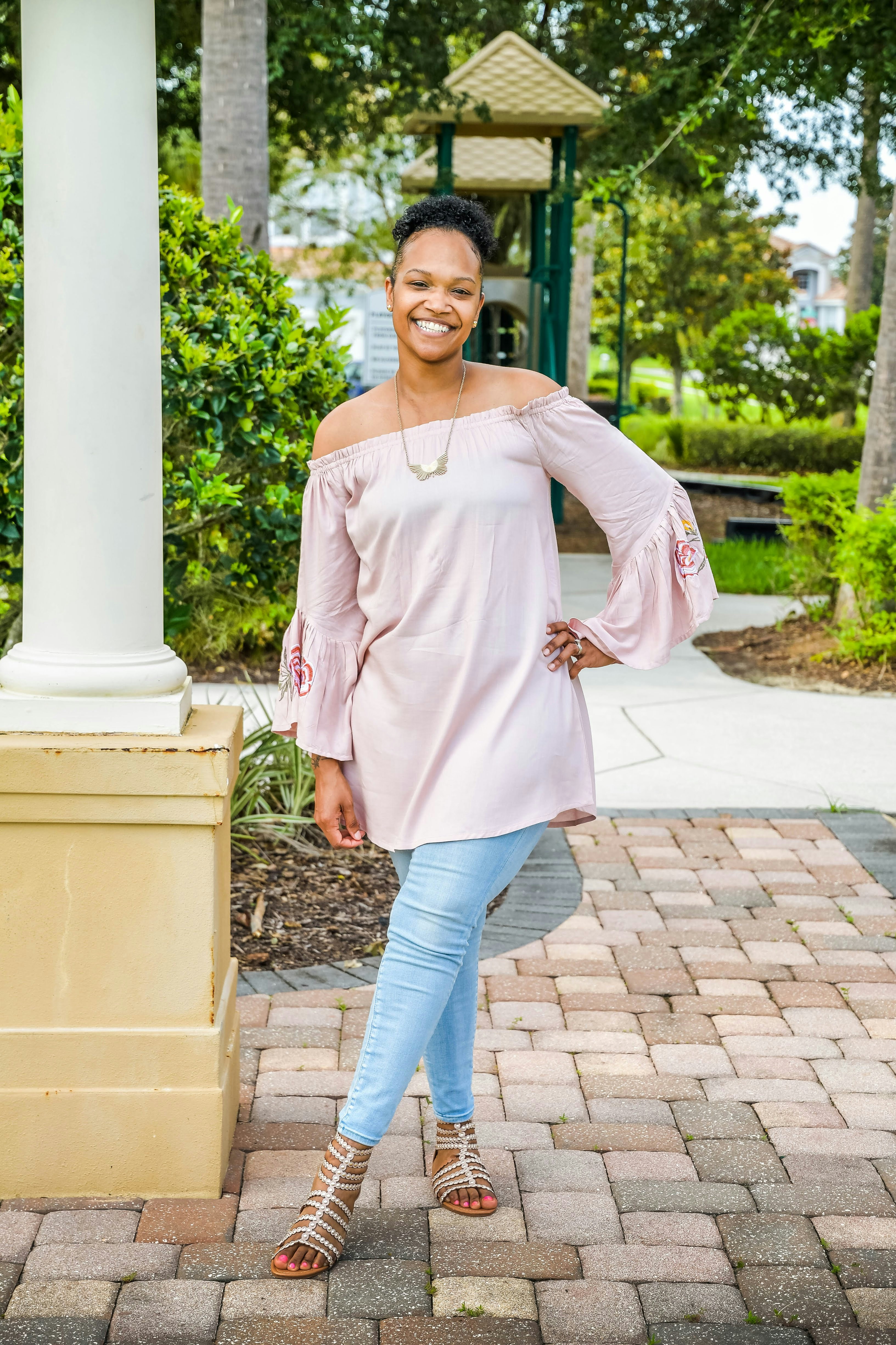 a woman standing in front of a white pillar