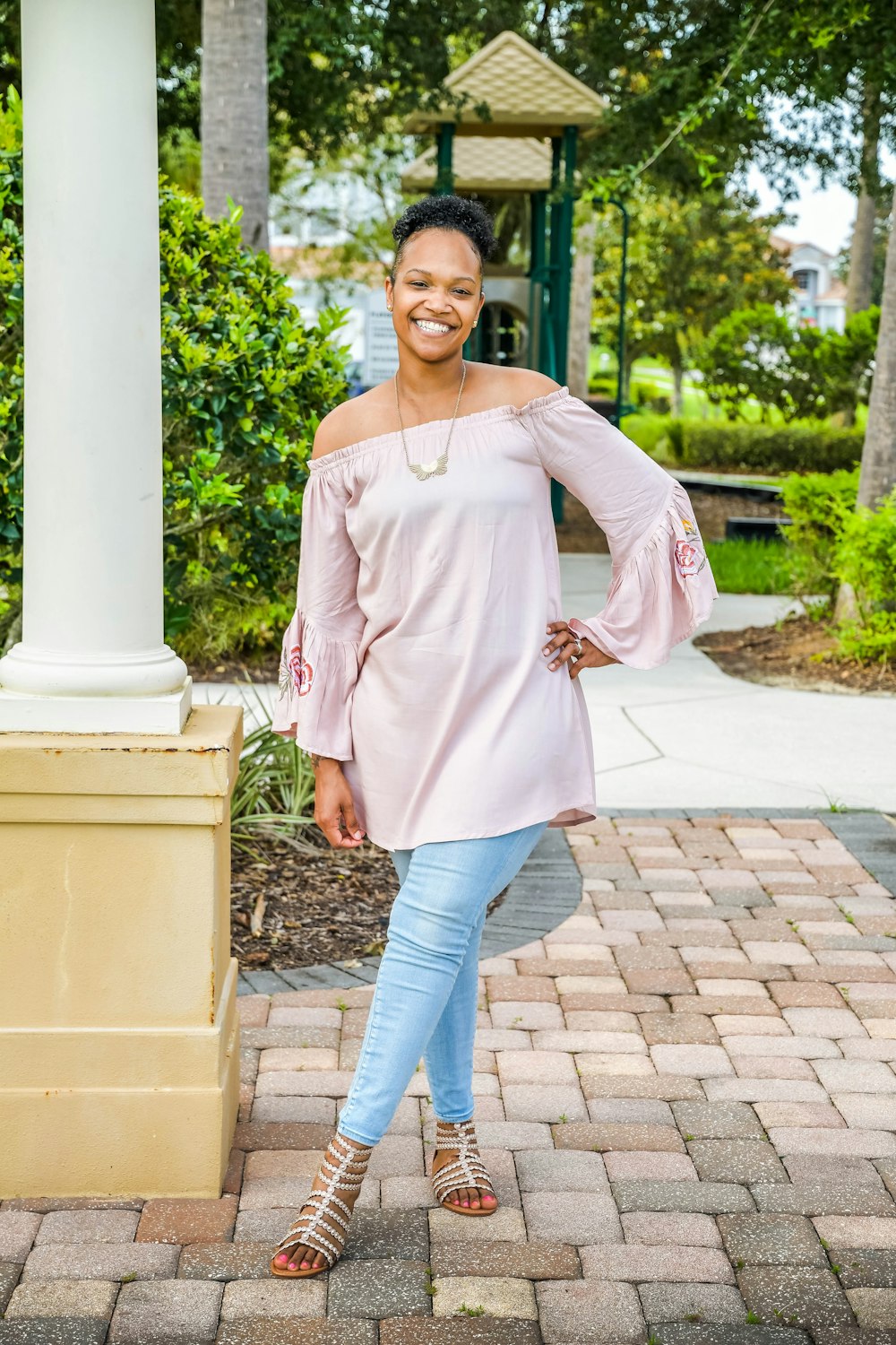 a woman standing in front of a white pillar