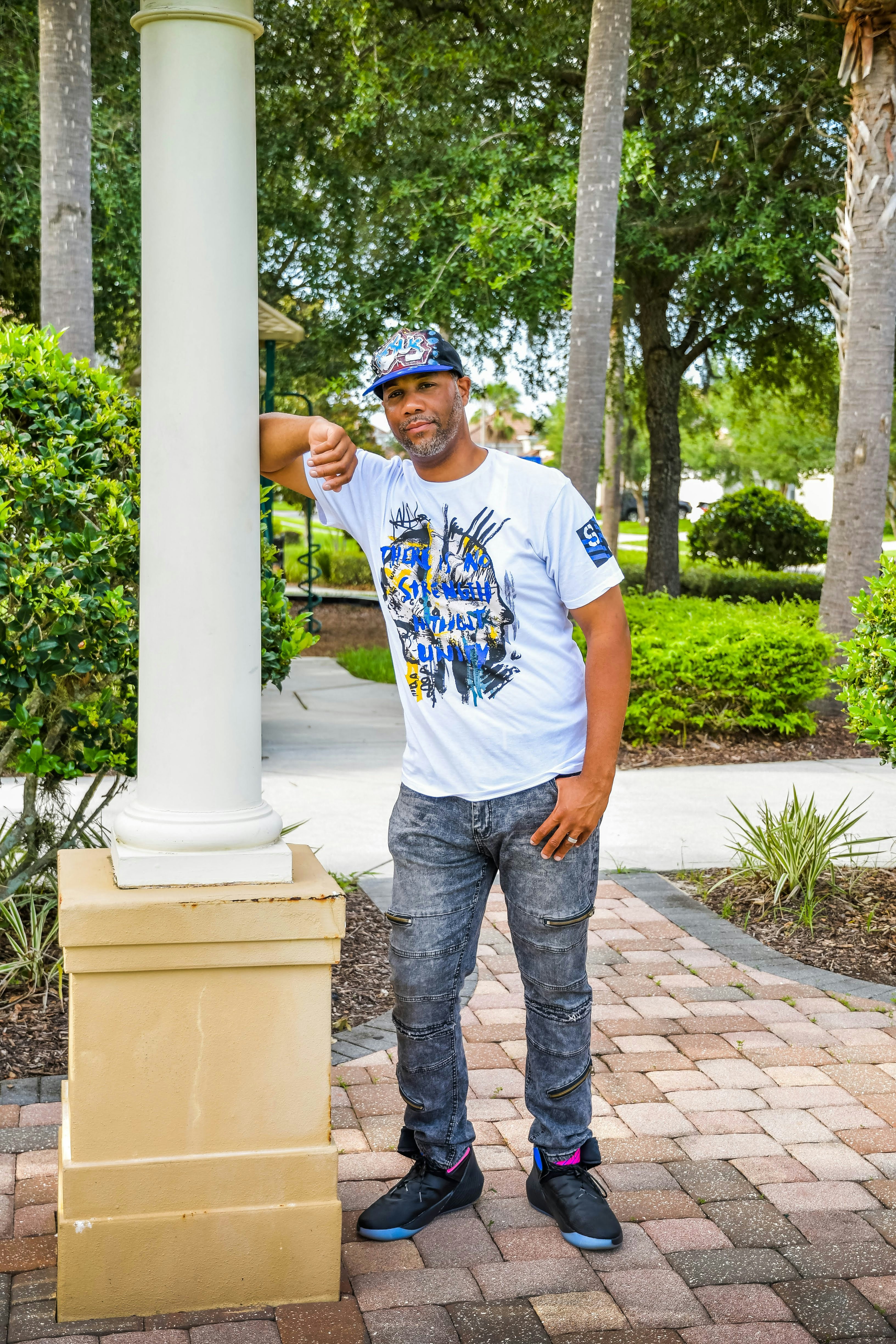 a man standing next to a white pillar