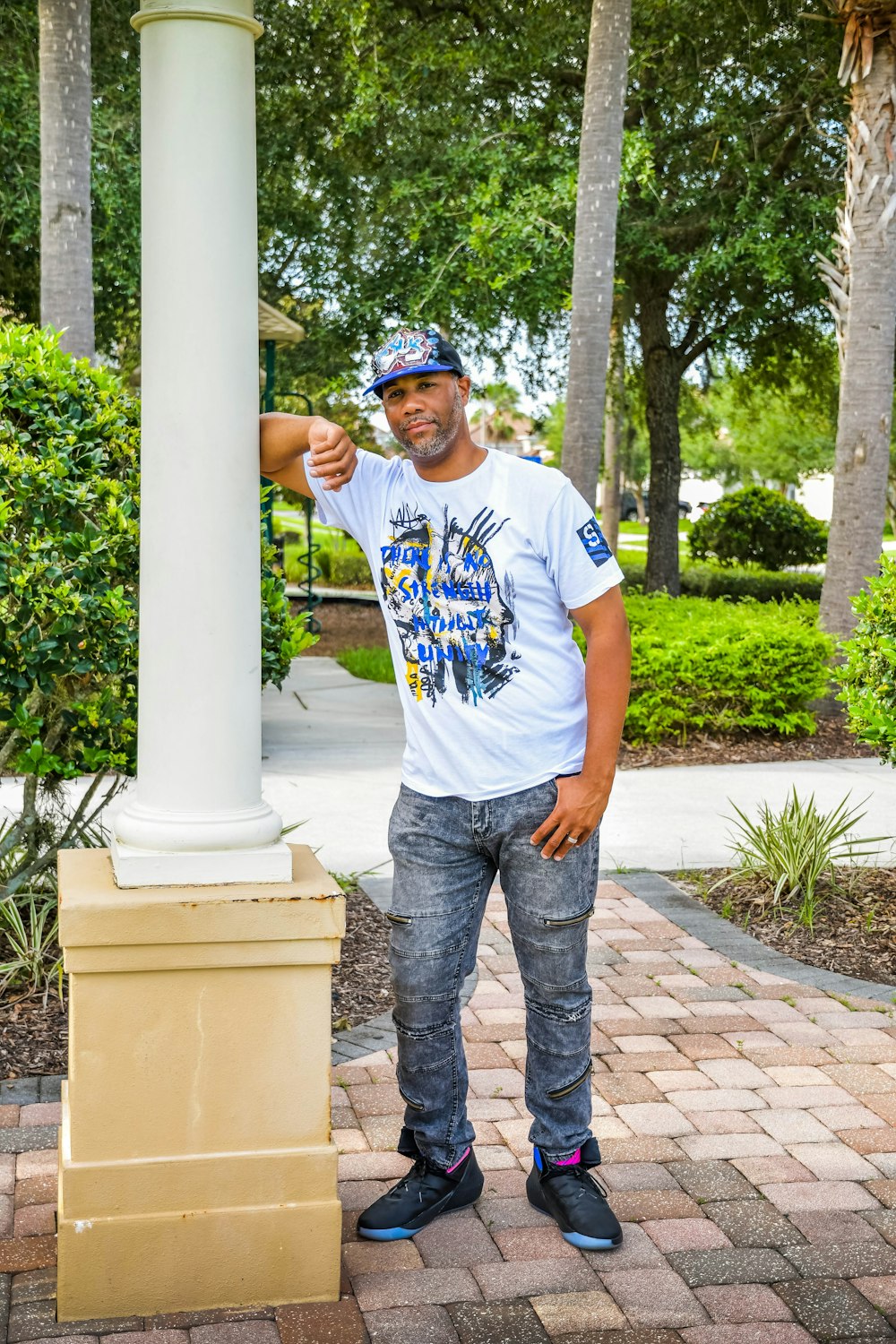 a man standing next to a white pillar