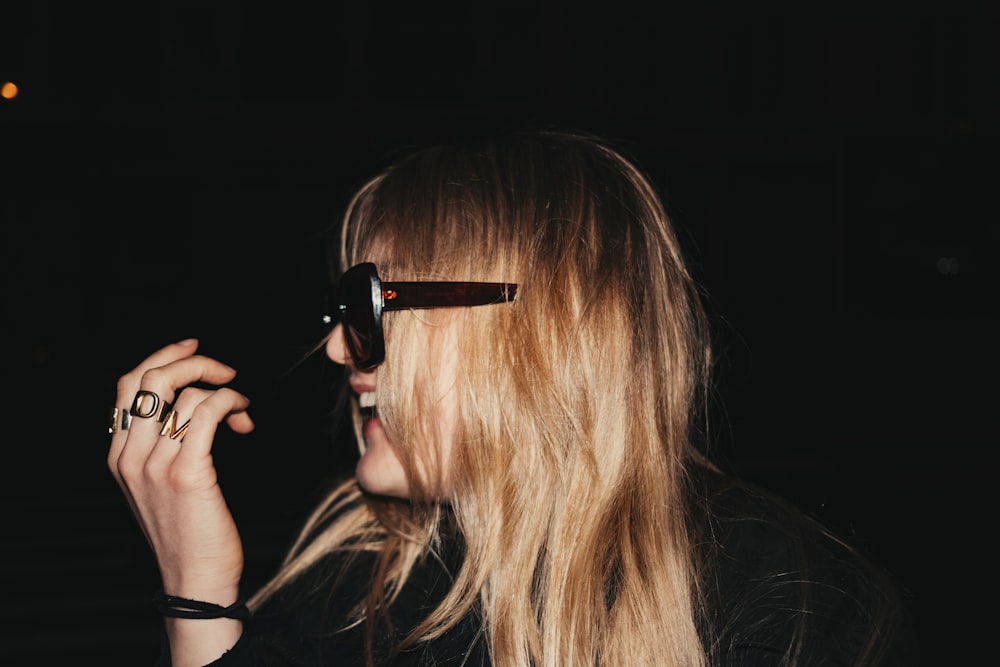 a woman with long blonde hair wearing sunglasses