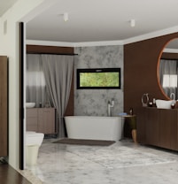 A modern bathroom featuring a free-standing bathtub against a textured wall with a narrow horizontal window above it. There is a large circular mirror above a wooden vanity, complemented by a minimalist sink and faucet design. Neutral colors dominate the room, with accents of brown and gray. A soft rug is placed on the tiled floor, adding warmth to the space. Elegant drapes frame a side window, softening the overall atmosphere.