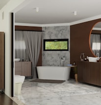 A modern bathroom featuring a free-standing bathtub against a textured wall with a narrow horizontal window above it. There is a large circular mirror above a wooden vanity, complemented by a minimalist sink and faucet design. Neutral colors dominate the room, with accents of brown and gray. A soft rug is placed on the tiled floor, adding warmth to the space. Elegant drapes frame a side window, softening the overall atmosphere.