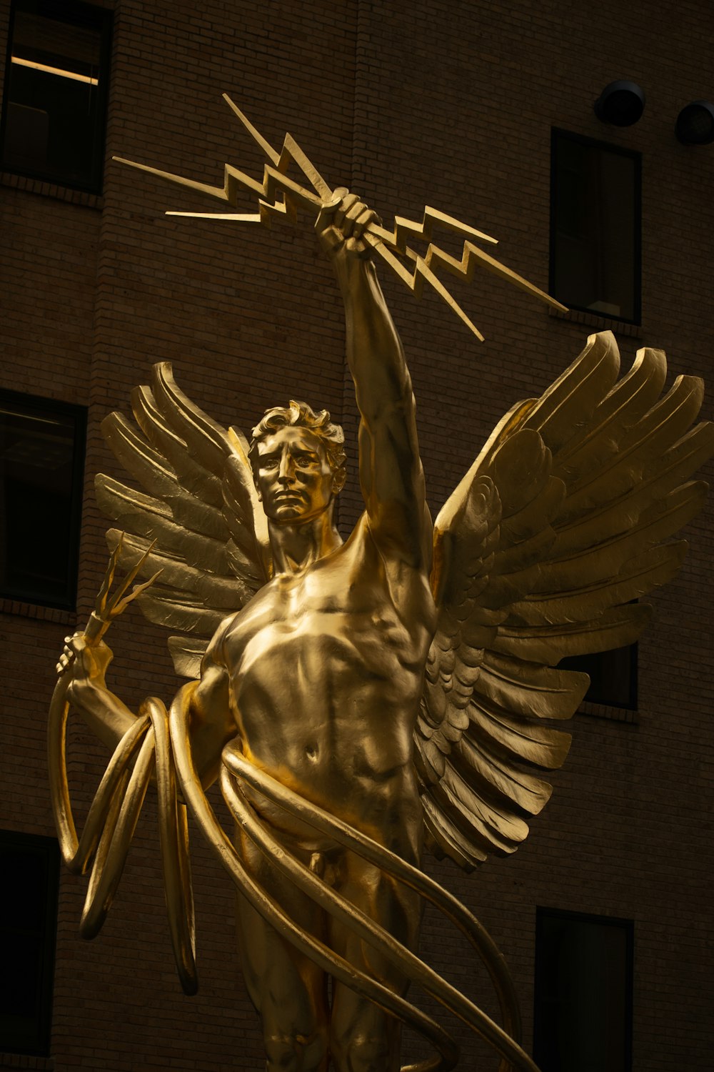 a golden statue of a man holding a bird