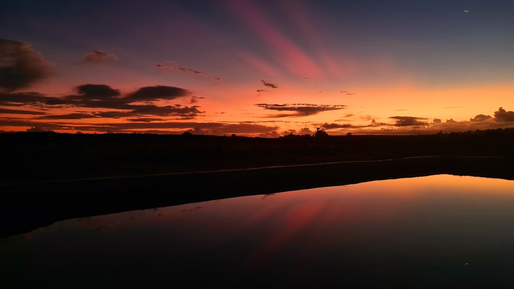 the sun is setting over a body of water