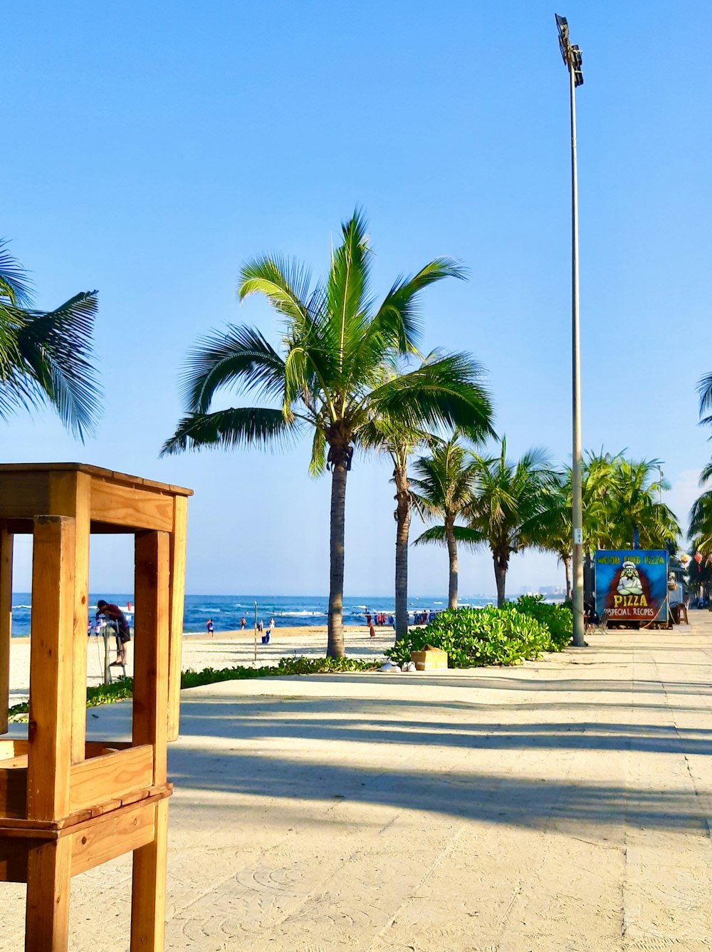 a wooden bench sitting on top of a sandy beach