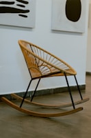 a wicker rocking chair sitting in front of a wall