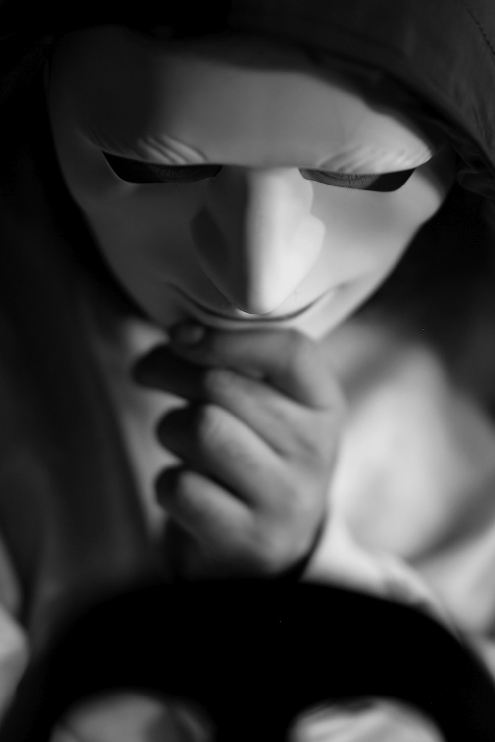 a black and white photo of a woman covering her face