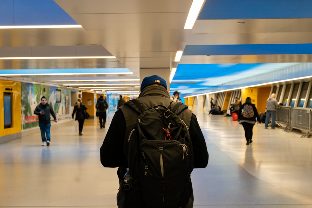 a person with a backpack walking down a hallway