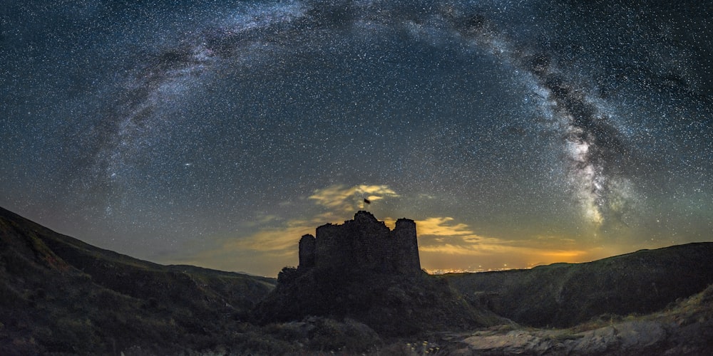 the night sky with stars above a castle