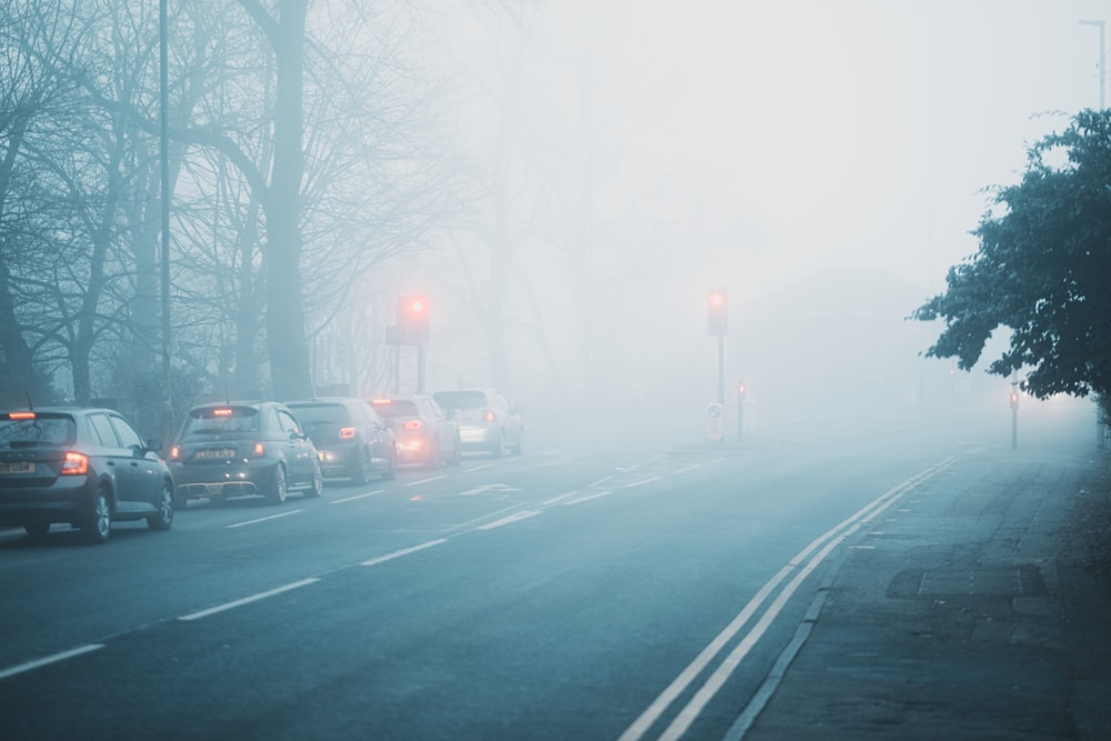 a street filled with lots of traffic on a foggy day