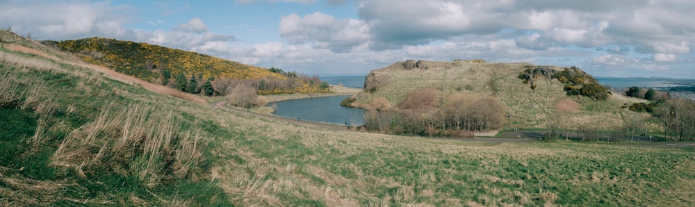 una colina cubierta de hierba con un lago en medio de ella