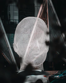 a large sculpture of a person's head in front of a building