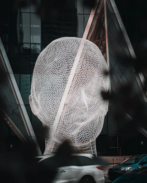 a large sculpture of a person's head in front of a building