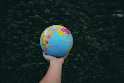 a person holding a small globe in their hand