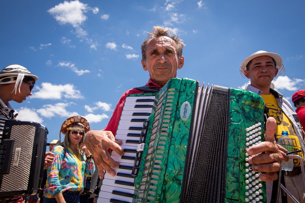 a man holding an accordion in front of a group of people