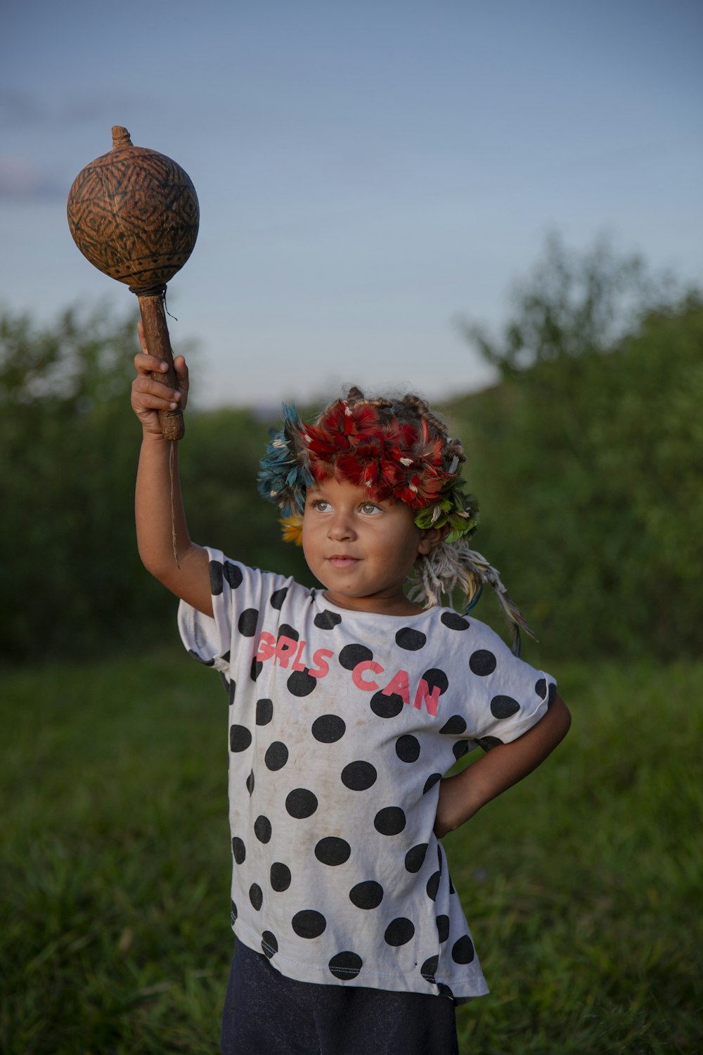 a little girl holding a wooden ball in her hand