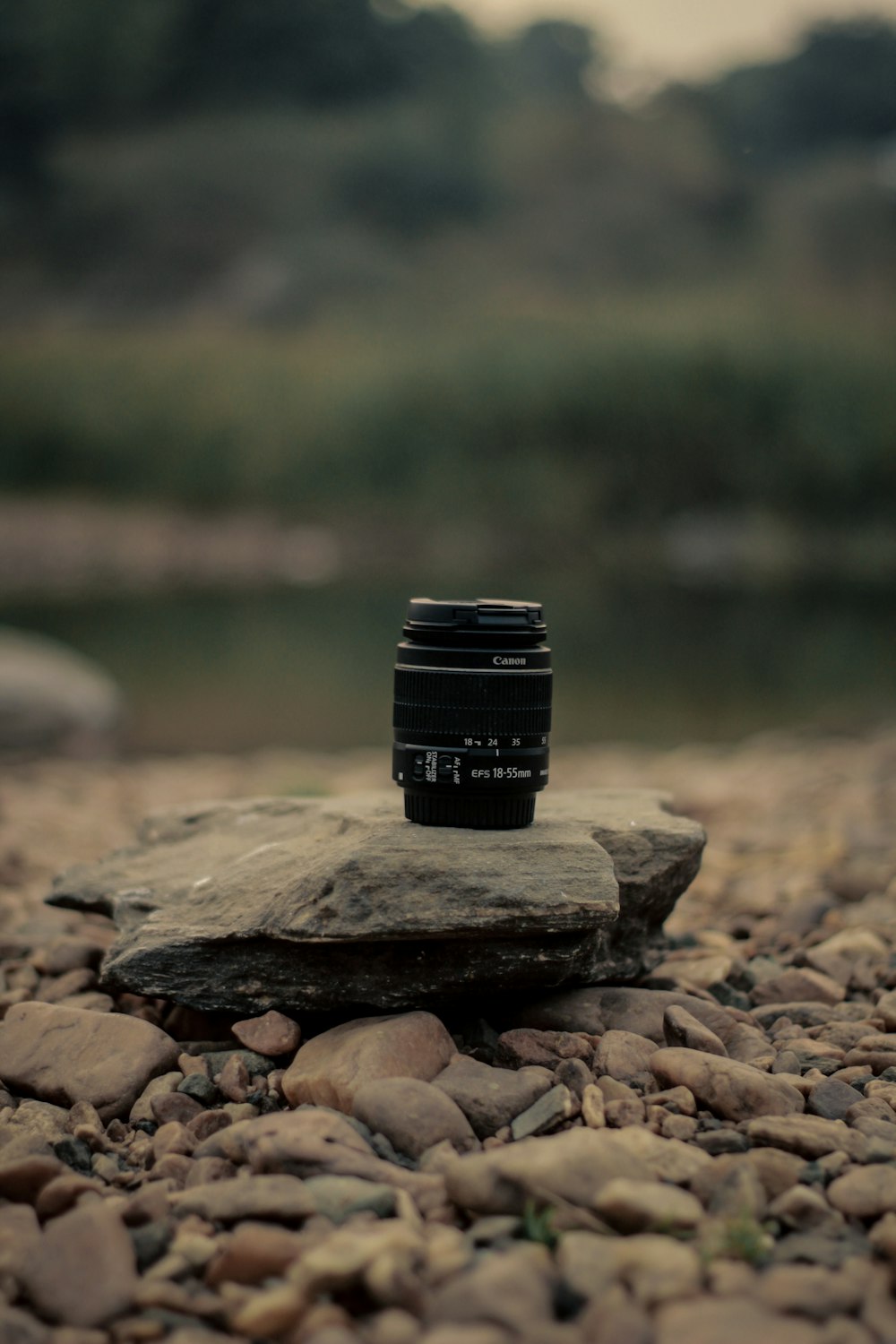 a camera lens sitting on top of a rock