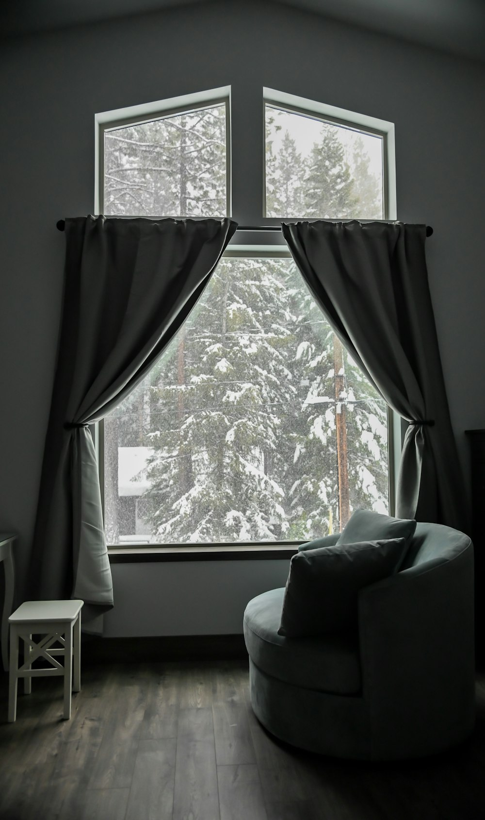 a chair sitting in front of a window covered in snow