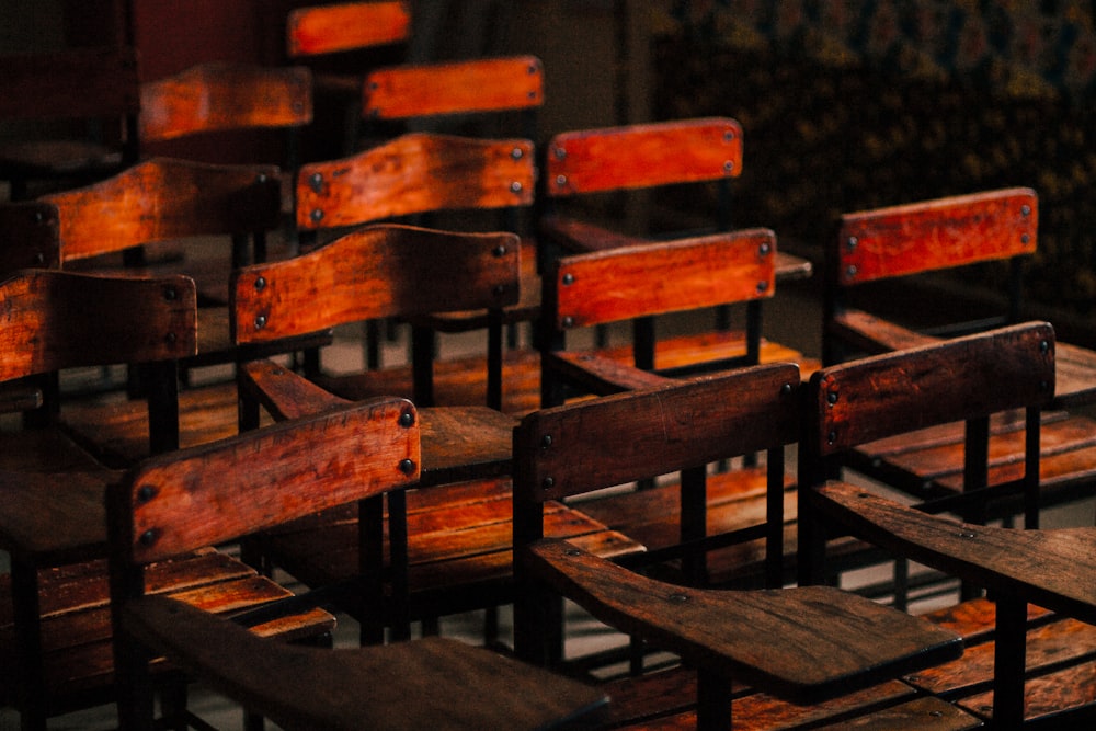 a row of wooden chairs sitting next to each other