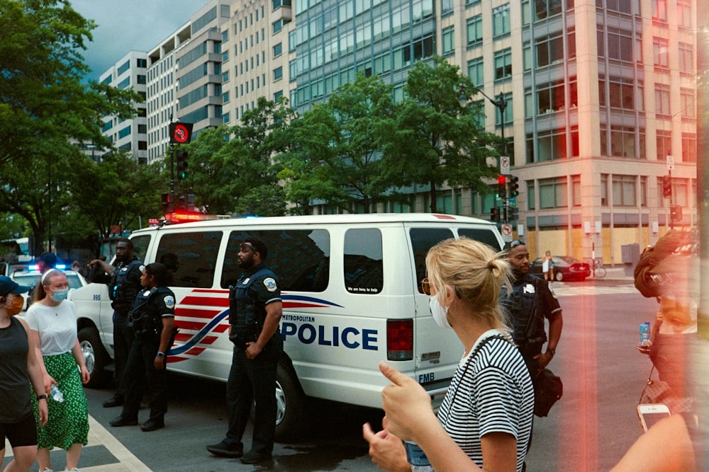 a group of people standing around a police van