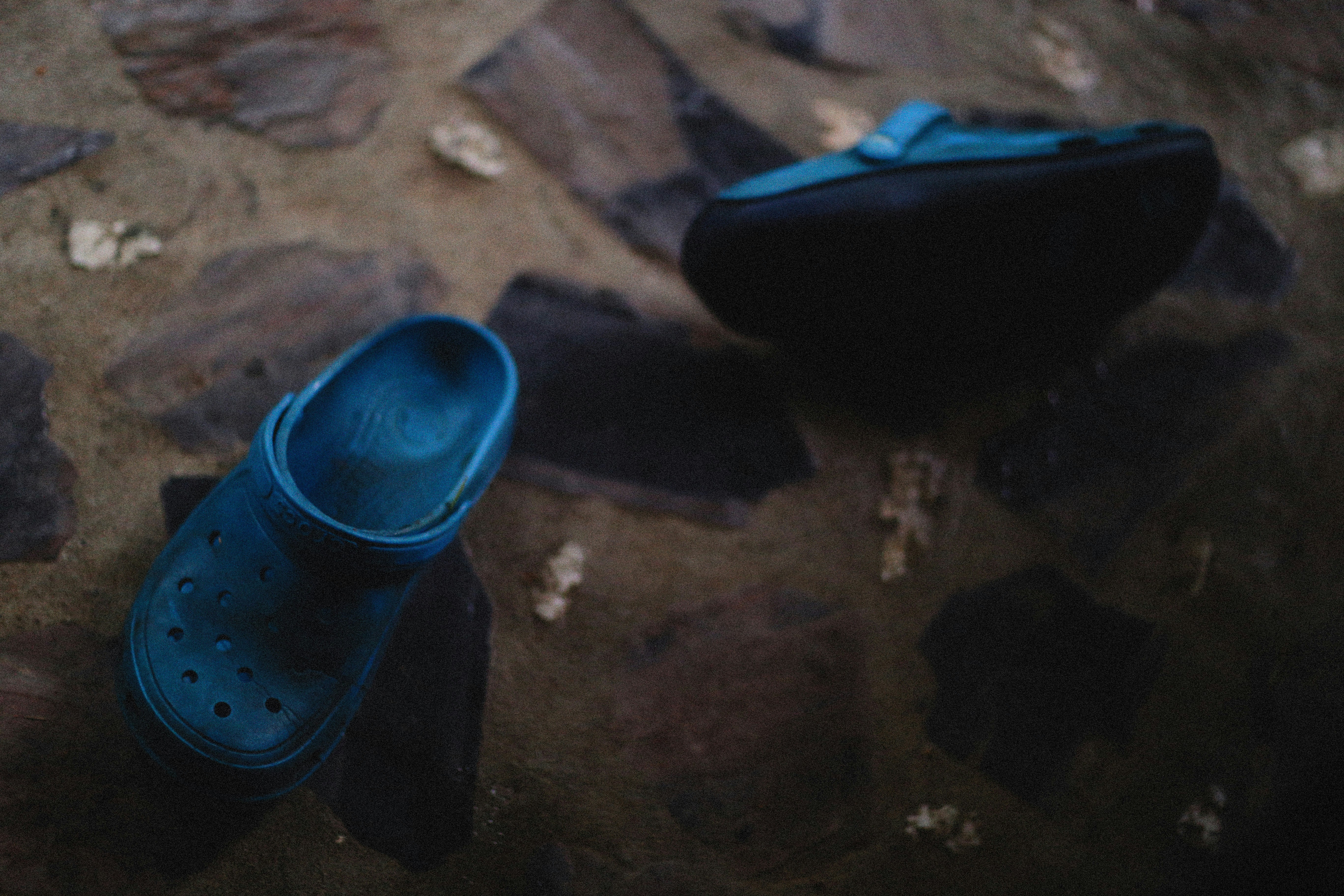 a pair of blue shoes sitting on top of a stone floor