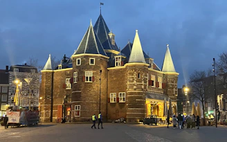 Historic brick lodge building with a warm evening glow and members gathered on the front steps.