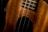 Close-up view of a wooden stringed instrument with intricate carvings around the soundhole. The image highlights the rich texture and craftsmanship of the wood.