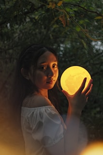 A model wearing a flowing dress that seems to capture the glow of the moon in its fabric