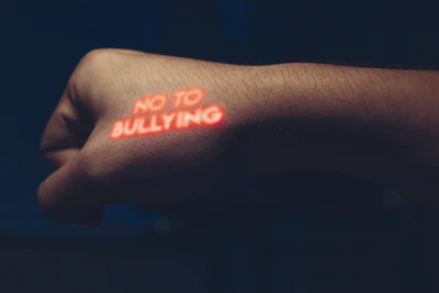 a person with a neon sticker on their arm saying no to bullying