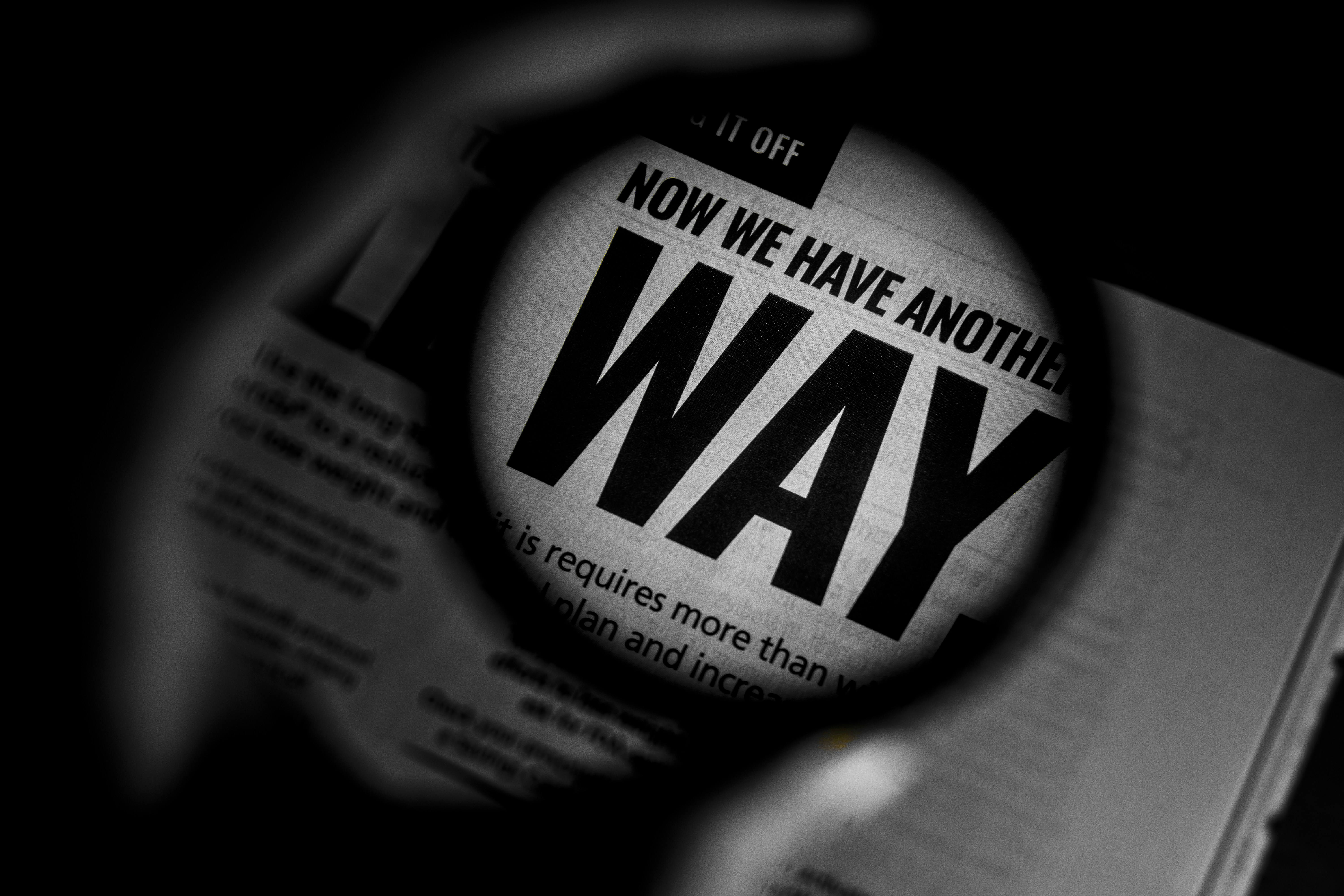 a magnifying glass over a newspaper with the words now we have another way