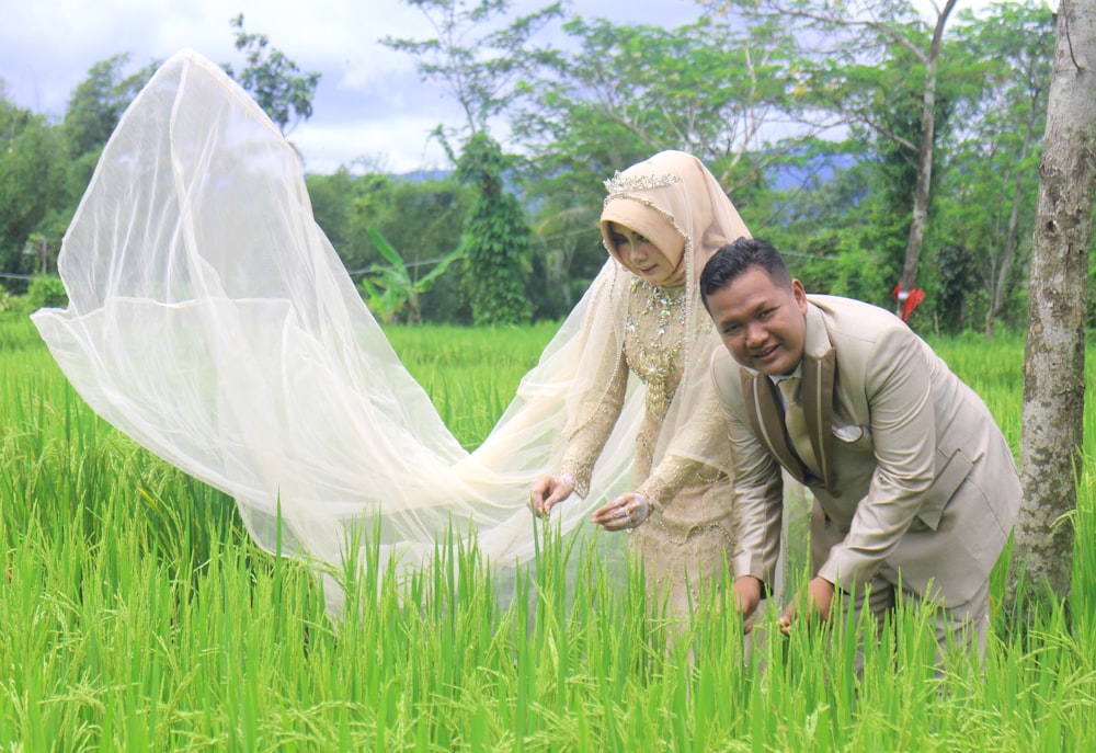 a man and a woman in a field with a veil