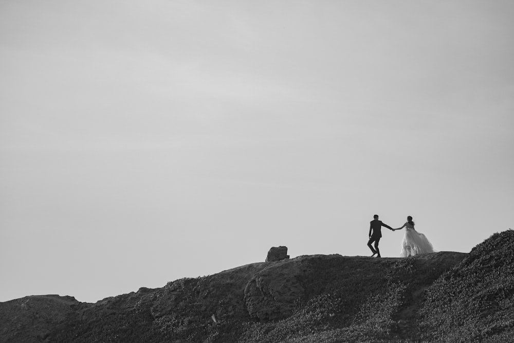 a couple of people that are standing on a hill