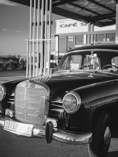 The car parked beside a modern cafe, highlighting its unique design in an active urban setting.