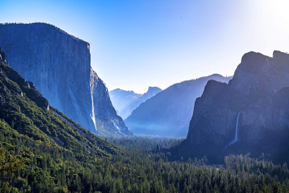 a view of a valley with mountains and trees