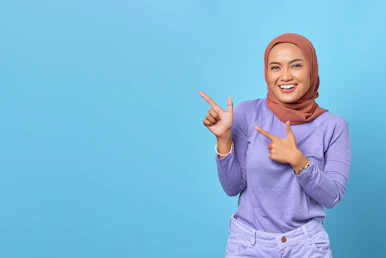 a woman in a hijab pointing to the side