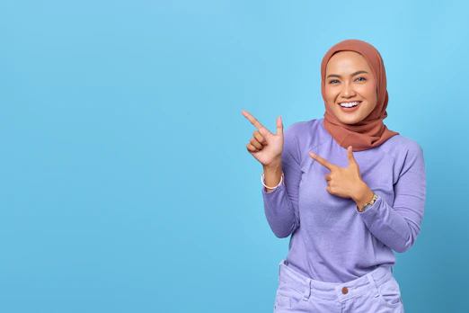 a woman in a hijab pointing to the side