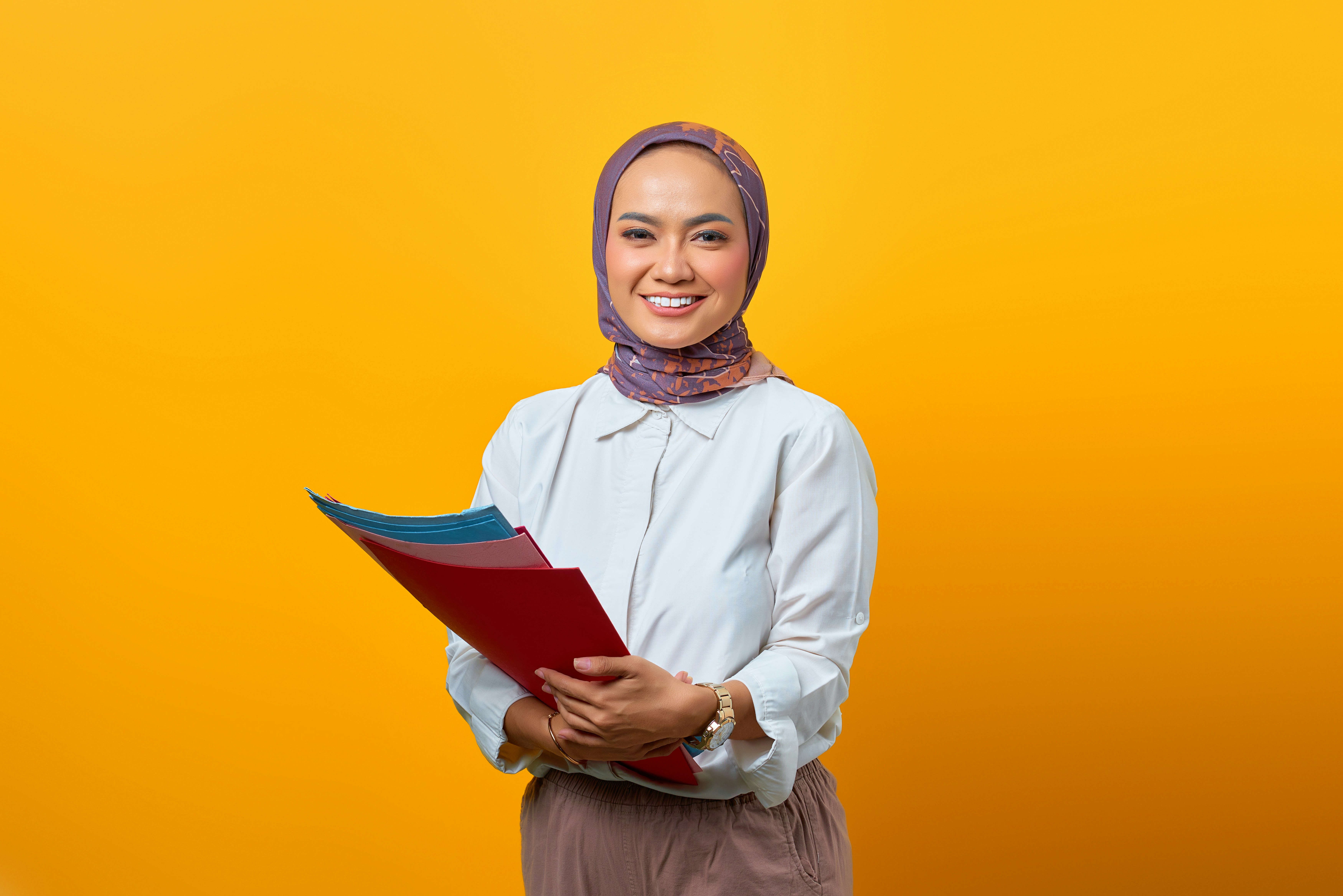 a woman in a headscarf holding a folder