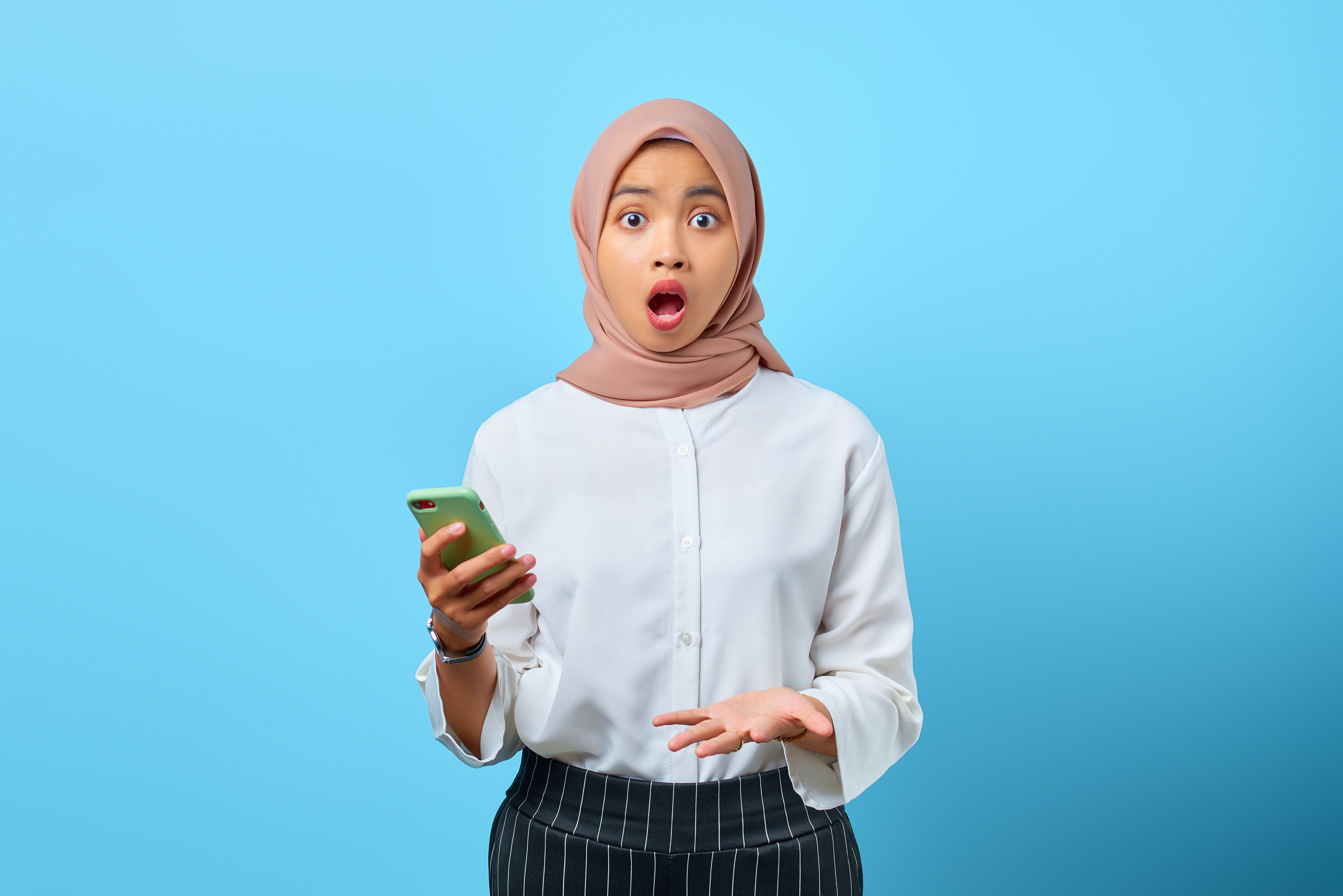 a woman in a hijab holding a cell phone