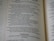 An open book with text visible on both pages. The blue and black text appears to include verses and religious references, indicating it might be a religious or spiritual text.