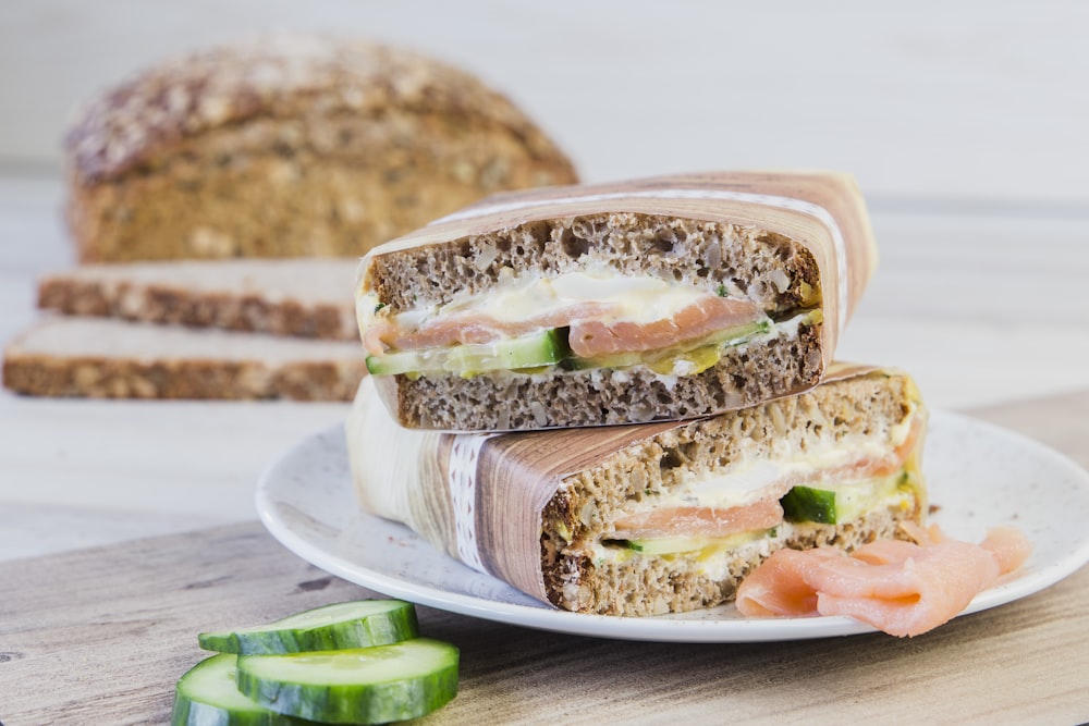 a sandwich cut in half sitting on top of a white plate