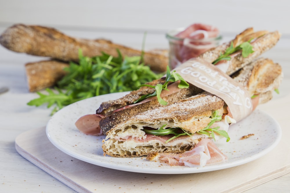 a white plate topped with a cut in half sandwich